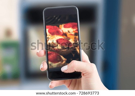 Photo on the social networking site of pastries. Woman photographing smartphone baked in the oven homemade casseroles.
