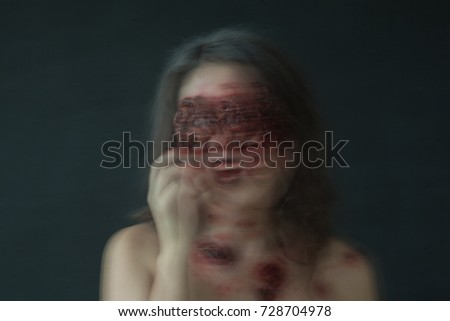portrait of a girl with realistic ulcers and worms crawling out of her eyes. creative halloween makeup. Blurred photo.