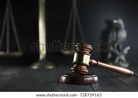 Law. Gavel and scales on dark background.