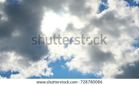 Beautiful cloudscape with large, building clouds and sunrise breaking through cloud mass