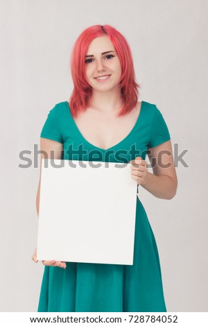 portrait of young woman with red hair holding sign card