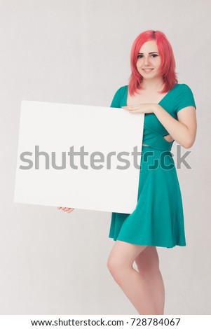 portrait of young woman with red hair holding sign card