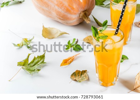 Fall and winter cold cocktails. Spicy pumpkin mojito with fresh mint, on white marble table. copy space