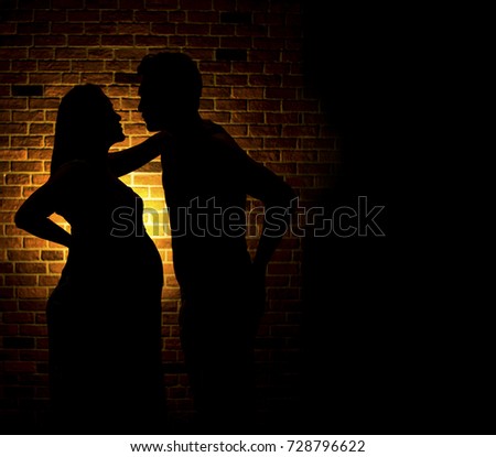 The Silhouette of Beautiful pregnant woman and her husband are happy while spending time together 