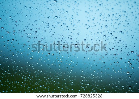 Raindrops on the windshield.Rain falls down the window.Water drops on glass caused by rain, close-up photography.