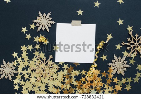 Christmas planning concept mock up. Note on black background with washi tape, gold stars confetti, serpentine and glitter snowflakes. Place for text flat lay