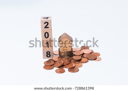 The wooden cube for new year with the house model and Thai coins on white background