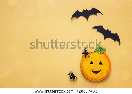Flat lay Halloween background with decorative pumpkin, spiders and bats on orange background. Blank space for text. Festive  concept. 