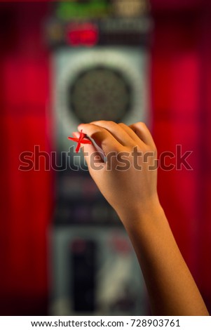Rear view of a woman playing darts 