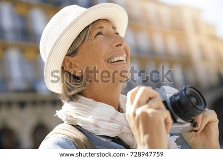 Senior woman taking pictures on tourist journey 