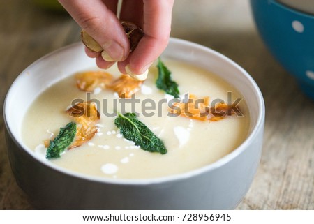 Apple and celeriac soup garnished with celeriac chips and fried sage