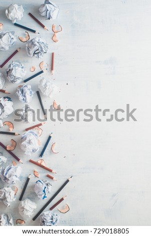 Flat lay frame with copy space. Writer workplace with minimalist pattern. Crumpled paper balls with pencils on a white wooden background, creative writing concept.