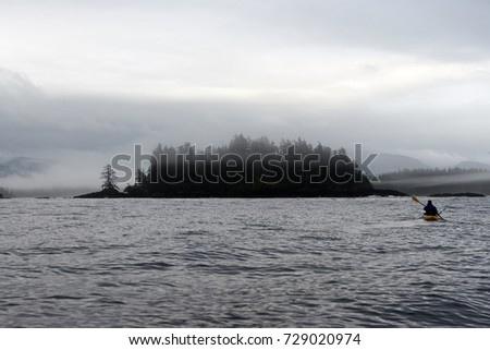 Kayaker paddling toward small woody island at Foggy Bay, Alaska, USA Royalty-Free Stock Photo #729020974