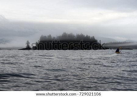 Kayaker paddling near small woody island at Foggy Bay, Alaska, USA Royalty-Free Stock Photo #729021106
