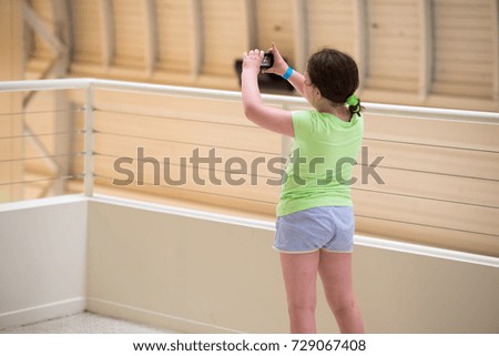 Young girl taking photographs at a museum