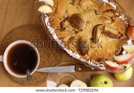 apple pie with cut and whole apples tea knife saucer close up photo