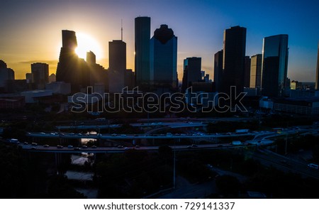 Sun rays beaming through the Houston Texas Downtown skyline cityscape sunrise at dawn in October 2017 aerial drone view of H-Town , highways , and skyscrapers travel destination