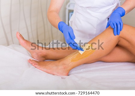 Woman cosmetologist working with sugar paste in a spa salon