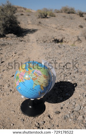Globe on a road in a mountain desert