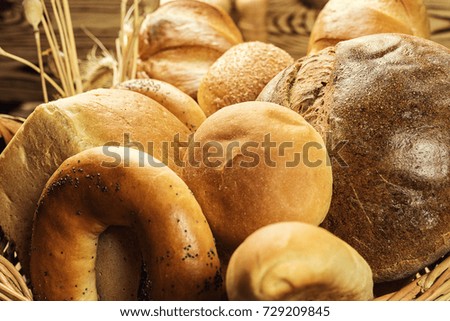 Composition with variety of baking products and buns inside basket. Bakery and grocery concept