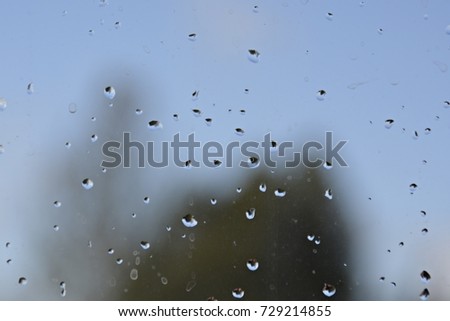 raindrops on a window in front of the sky