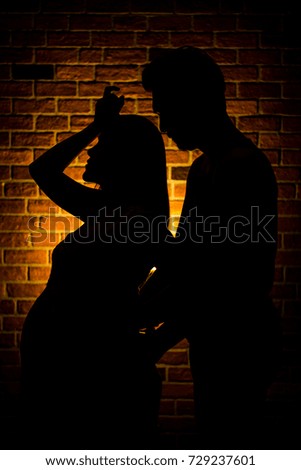 The Silhouette of Beautiful pregnant woman and her husband are happy while spending time together 