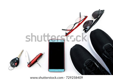 Travel accessories such as mobile phone and black sneaker and sun glass and key on white background
