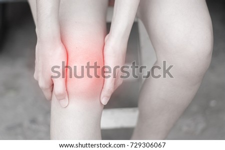 Close up woman having knee pain in medical office,A young woman massaging her painful knee