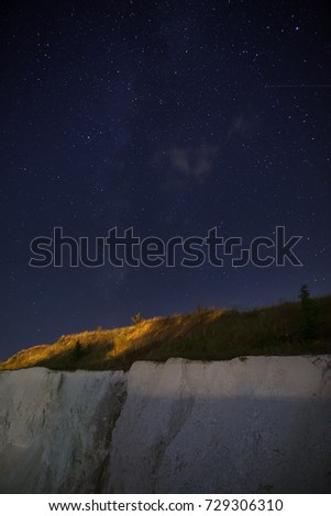 Night starry sky over the quarry for the extraction of chalk.