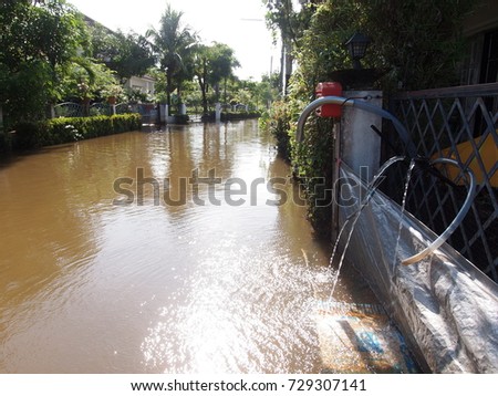 global warming effect in town, low level flood water in urban zone authentic picture shows brown dirty water in abandoned village under frequently repeated high level flood problem in city of THAILAND