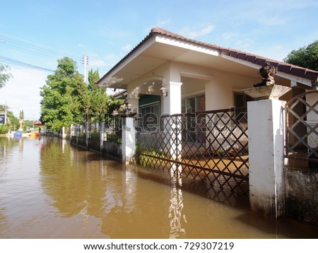 global warming effect in town, low level flood water in urban zone authentic picture shows brown dirty water in abandoned village under frequently repeated high level flood problem in city of THAILAND