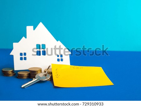 White house on a blue background with the keys to the apartment. Symbol of real estate, buying and selling a house by a realtor