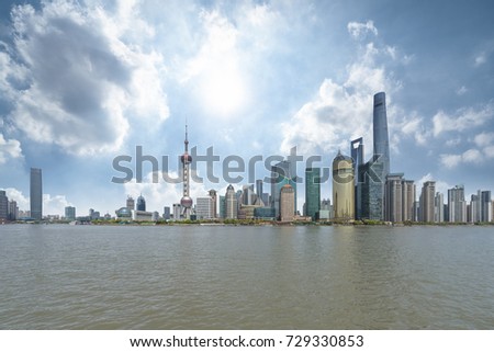 panoramic view of shanghai skyline with huangpu river under blue sky
