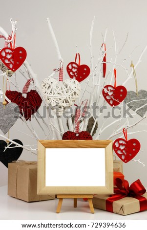 Blank photo frame and gifts on background of tree with valentines