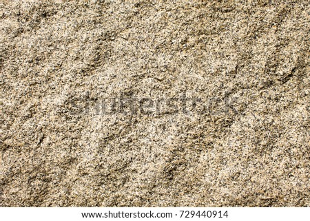 The granite surface of the wall is light brown in color.