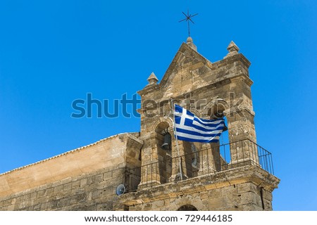 Greek church tower with a national Greek flag.