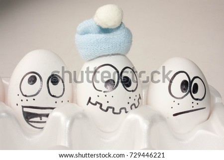 autumn came the concept. funny eggs with face. three friends. warm hat. photo for your design