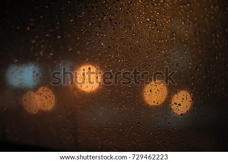 Amazing shot of the raindrops on the car’s windscreen with beautiful bokeh.Lowlight shot with selective focus and artificial grain effect.