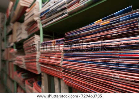 many magazines in the stacks lie on the shelves of the library's storage tinted in blue. horizontal frame