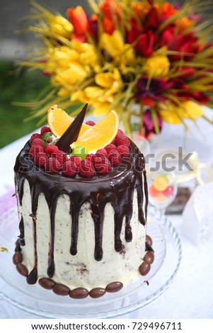 A festive table decorated with birthday cake with flowers and sweets. A table with a cake for the birthday of the child. Birthday party for children