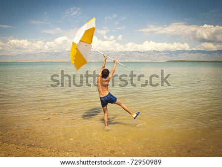 Young man holding an open beach umbrella
