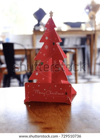 Red Christmas tree made by paper on wooden table.