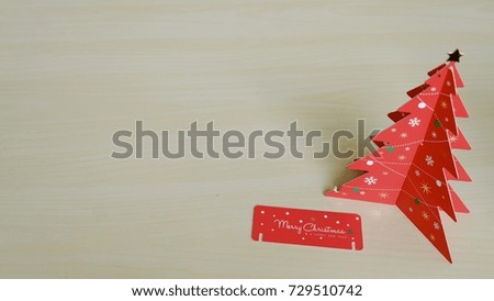 Red Christmas tree made by paper on wooden table with copy space.