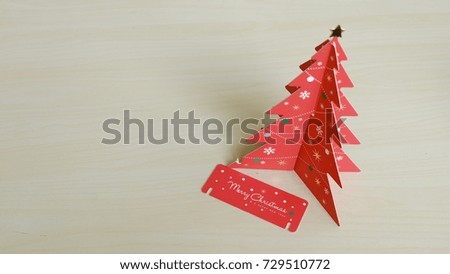 Red Christmas tree made by paper on wooden table with copy space.
