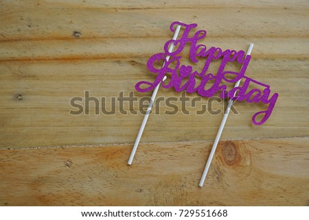 Top or flat lay view of birthday props happy birthday with purple happy birthday writing on a wooden background flat lay. Birthday parties text and props.