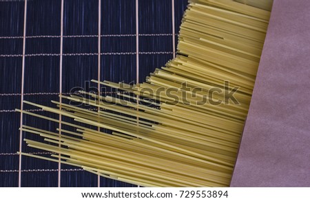 Spaghetti in brown paper bag on a checkered dark table