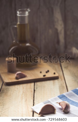 Flavored olive oil with garlic and pepper on wooden table. dark image. cover of the cookbook