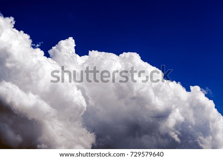 White cumulus fluffy clouds against a deep blue sky (background)
