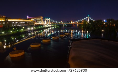 Night time long exposure from Mississippi River looking at bridges of Minneapolis and St. Paul, Minnesota USA. St. Anthony Falls and pylons form leading lines. 