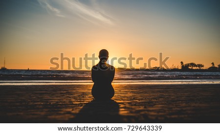 woman watches sunset on horseshoe beach costa rica
